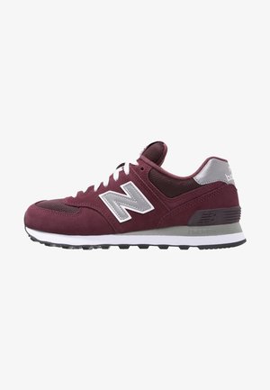 Zapatilla New Balance granate y gris con cordones blancos, parte superior de malla y ante, y suela acolchada con dibujo negro.