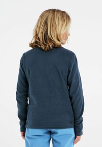 Marinblå fleece-tröja med långa ärmar och rund halsringning. Mjuk textur, figursydd design, med en liten svart etikett längst ner.