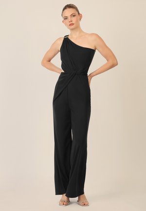 Jumpsuit nero a spalla unica con vita attorcigliata. Realizzato in tessuto morbido, presenta una silhouette elegante e minime applicazioni hardware.