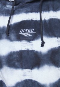 Sweatshirt com capuz, apresentando um padrão de tie-dye em azul marinho e branco, com cordão preto e logótipo bordado "HI-TEC" no peito. Textura suave.