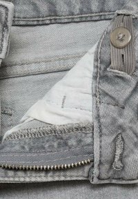 Grijze denimstof met een zichtbare rits, knoopsluiting en binnenvoering. Bevat stikdetails en een gladde textuur.