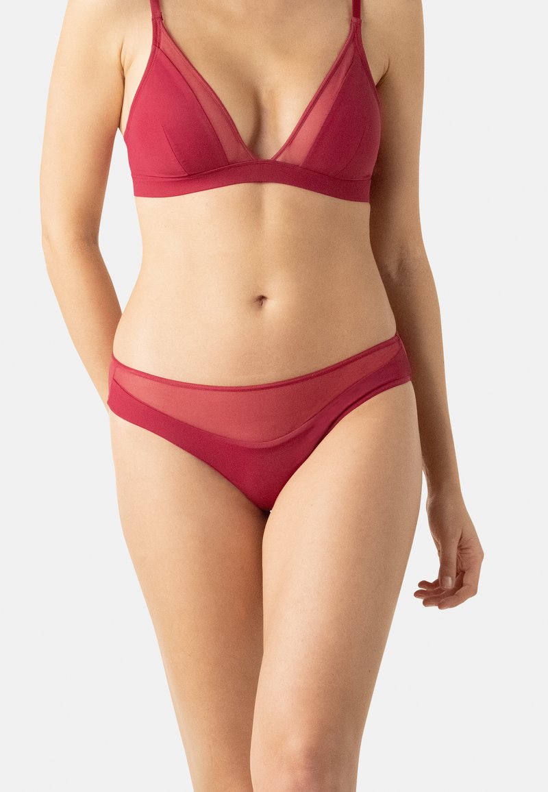 Ensemble de lingerie rouge composé d'un bralette en mesh doux et transparent avec des bonnets triangulaires et des culottes taille basse assorties avec une ceinture lisse.