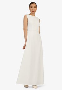 Weißes ärmelloses Maxikleid mit einem taillierten Oberteil und einem fließenden Rock. Glattes Material und minimalistisches Design, das eine subtile Naht in der Taille aufweist.