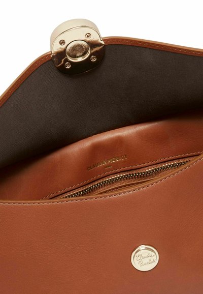 Bolso de piel marrón con cierre y cremallera dorados, con la marca "Claudie Pierlot" visible en el interior y el logo metálico en la parte delantera.