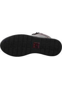 Schwarze Gummisohle mit strukturiertem Grip. Obermaterial aus braunem Leder mit einem seitlichen Reißverschluss und genähten Akzenten. Detailliertes Logo auf der Sohle sichtbar.