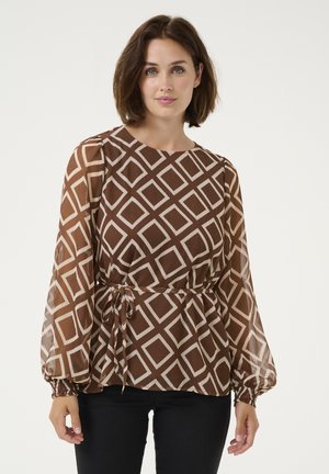 Brown patterned blouse with a geometric diamond design, long sleeves with elastic cuffs, and a drawstring waist. Sheer fabric texture.