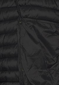 Black puffer vest with quilted texture, featuring zippered pockets and a sleek design. Smooth fabric with a lightweight appearance.