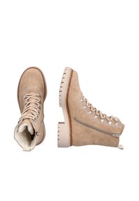Botas de senderismo de gamuza beige con herrajes plateados, diseño con cordones y cremallera lateral. Suela de goma gruesa y texturizada para tracción. Interior forrado.