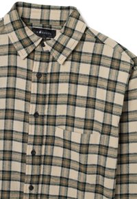 Camisa de cuadros beige con cuadros en verde oscuro y marrón, cuello con botones, mangas largas y un bolsillo en el pecho.