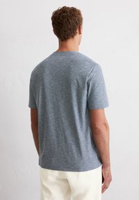 Kurzarm-T-Shirt mit Rundhalsausschnitt in Hellblau, mit einer subtilen melierten Textur, aus weichem, atmungsaktivem Stoff.