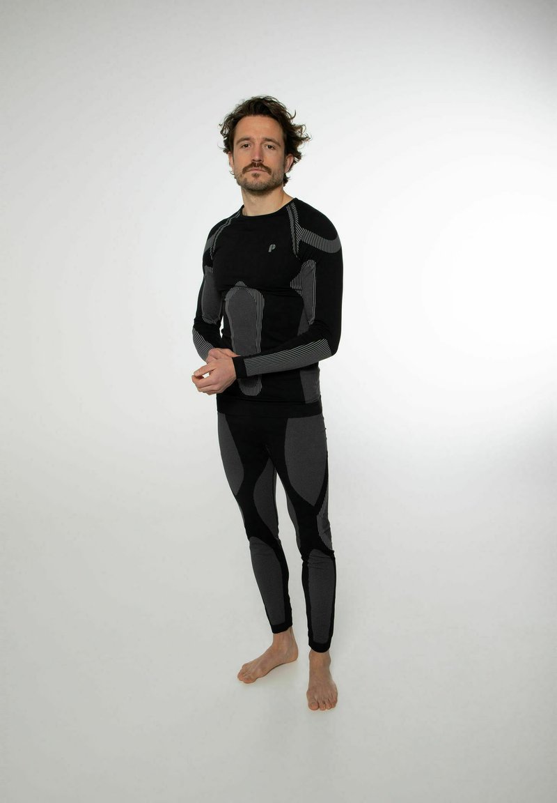 Set di base layer atletico nera composto da una maglia a maniche lunghe e pantaloni aderenti, con accenti a righe grigie e pannelli testurizzati per un supporto migliore.