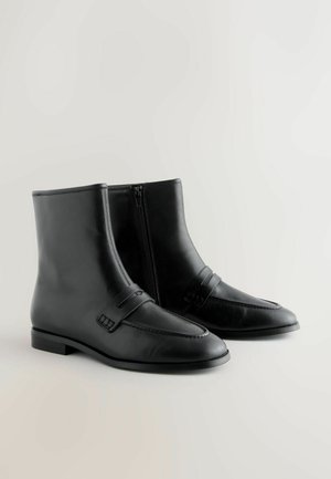 Botines de cuero negro con un acabado suave, que cuentan con una cremallera lateral, detalle de correa en el empeine y un tacón bajo en bloque.