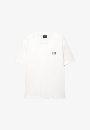 Weißes Baumwoll-T-Shirt mit Rundhalsausschnitt und kurzen Ärmeln, das ein kleines Grafikdesign mit drei kreisförmigen Motiven auf der linken Brustseite zeigt.