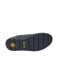 Sole di scarpa in gomma nera con motivo di grip testurizzato e scanalature orizzontali. Presenta un logo circolare al centro e flessibilità lungo i bordi.