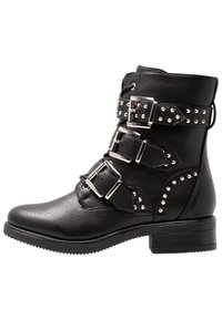 Stivale in pelle nera alla caviglia con tre fibbie regolabili, inserti a borchie, punta arrotondata e tacco basso a blocco con suola texturizzata.