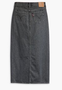 Spijkerrok in donkere wassing met een tailleband, achterzakken met een puntig ontwerp en een label aan de achterkant. Rechte snit, knielengte.