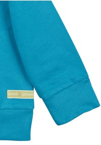 Indumento a maniche lunghe turchese con una trama morbida, dotato di un polsino e un'etichetta cucita con "loud + proud" in bianco e verde.
