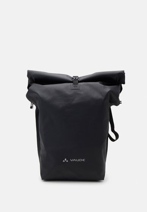 Zwarte roll-top rugzak gemaakt van duurzaam materiaal, met een veilige sluiting met gesp, zijrits en het "Vaude" logo in het wit gedrukt.