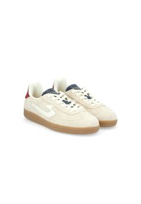Sneaker in suede beige con lacci bianchi e logo bianco. Presentano una suola in gomma texturizzata e un accento blu notte e rosso sul tallone.