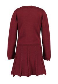 Viininpunainen neulemekko, jossa on pitkät hihat, kauniisti muotoiltu kaula-aukko, teksturoitu letkuvointi ja levenevä hame.