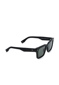 Lunettes de soleil rectangulaires noires avec des montures épaisses et des verres teintés foncés reposant en biais sur une surface blanche.