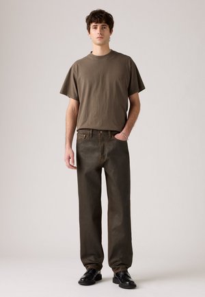 Olijfgroen katoenen t-shirt met korte mouwen, gecombineerd met donkergroene rechte broek. Draagt het met zwarte schoenen, wat een casual uitstraling creëert.