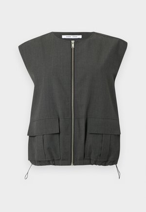 Grå ermeløs vest med glidelås foran, to frontlommer, elastisk kant og lett strukturerte skuldre. Laget av teksturert stoff.