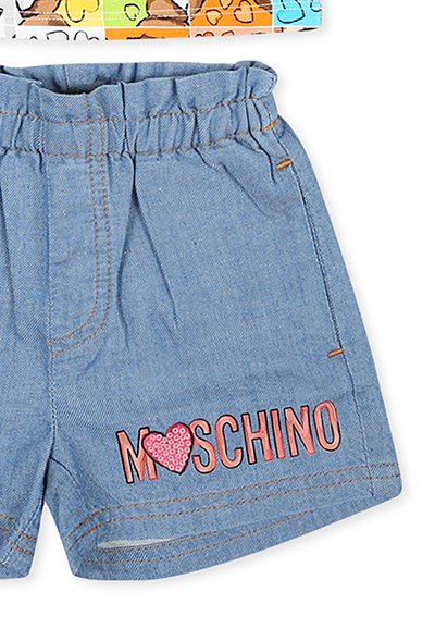Denimshorts med en samlet talje, lyseblå farve, orange syninger og "MOSCHINO" tekst med et hjerte-design i pink palietter.