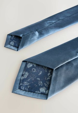 Seidene blaue Krawatten mit spitzen Enden. Der innere Stoff zeigt ein Blumenmuster auf einem dunkelblauen Hintergrund. Glatte Textur mit glänzendem Finish.