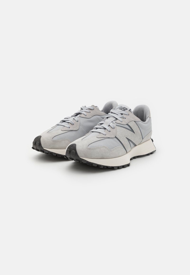 Graue Sneakers mit einem Obermaterial aus Mesh und Wildleder, ausgestattet mit einer gepolsterten Sohle, runder Zehenpartie und einer schwarzen Gummisohle mit strukturierten Details.