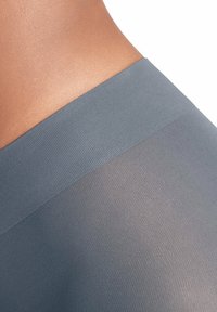 Tessuto grigio opaco con una superficie liscia. Presenta una ampia cintura elastica ed è leggermente trasparente nella parte inferiore.