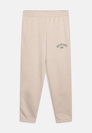 Beige Sweatpants aus weichem Material mit einem elastischen Bund und einem Aufdruck mit der Aufschrift "New Balance 1906" in Dunkelgrau am linken Bein.