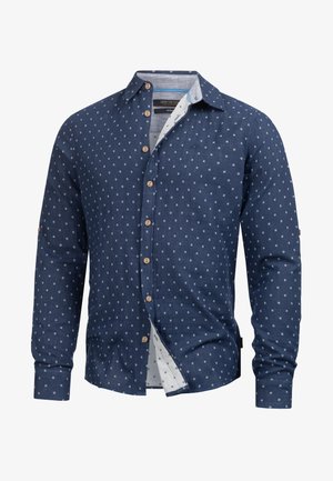 Camicia a maniche lunghe blu navy con motivo geometrico bianco, interno del colletto a contrasto e bottoni in legno. Tessuto leggero e vestibilità comoda.