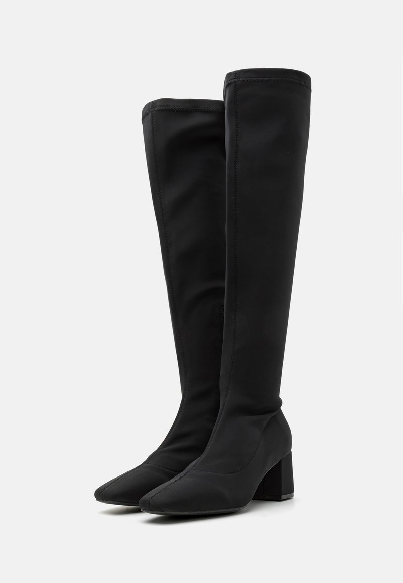 Czarne kozaki do kolan wykonane z gładkiego materiału, z kwadratowym noskiem i blokowym obcasem. Czysty design z minimalną ilością szwów.