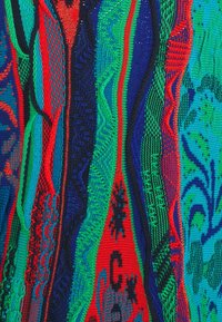 Bunt gestrickter Stoff mit vertikalen Streifen in Rot, Grün, Blau und Schwarz, der verschiedene strukturierte Muster und gewebte Designs aufweist.