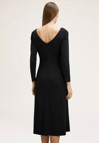 Schwarzes Midi-Kleid mit langen Ärmeln, V-Ausschnitt und tailliertem Schnitt. Glattes Material, knielang, mit einem Reißverschluss auf der Rückseite.