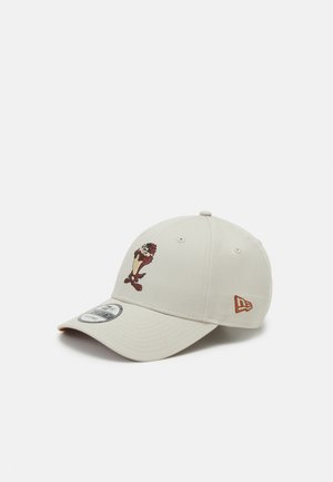Beige baseball cap featuring an embroidered Tasmanian Devil character on the front and a small New Era logo on the side.
