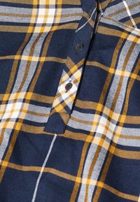 Tmavě modrá kostkovaná košile s pruhy v žluté, bílé a šedé barvě, vyrobená z látky s jemně texturovaným povrchem, zdobená čtyřmi knoflíky.
