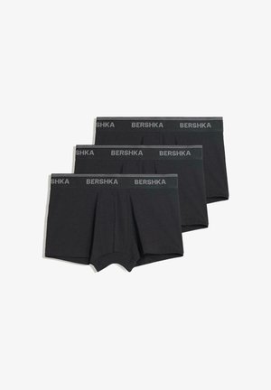 Caleçons boxers noirs en coton, dotés d'une ceinture extensible avec le logo 'BERSHKA' en gris. Trois paires exposées ensemble.