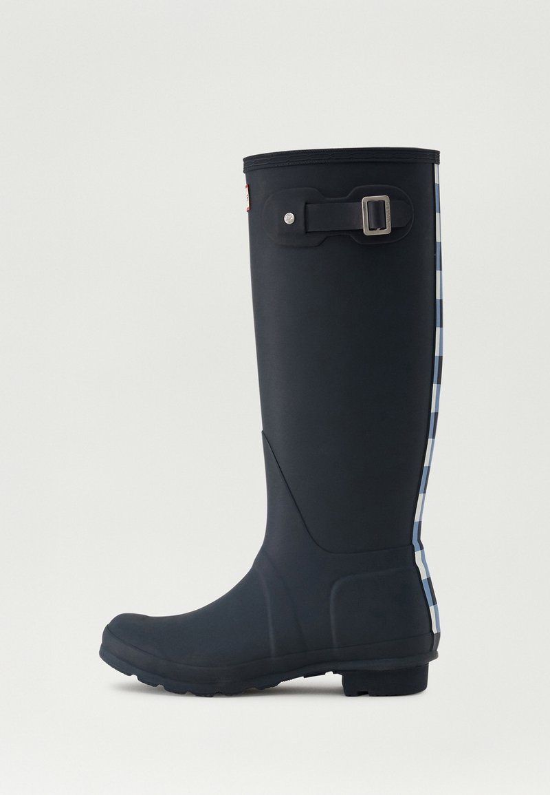Botas de lluvia negras de goma con un broche lateral, patrón a cuadros azul y blanco en la parte trasera, y suela texturizada para mayor agarre.
