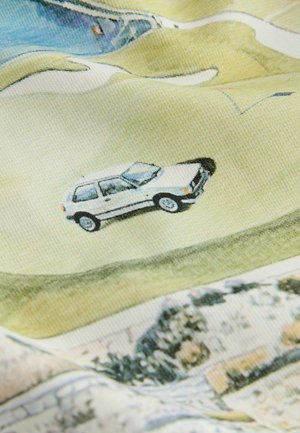 Hvid bil kører på snoet vej gennem kuperet landskab med grønne marker og spredte træer på tekstureret stofbaggrund.