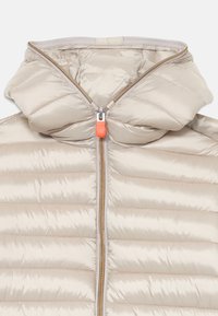 Beige Steppjacke mit horizontalen Nähten, hohem Kragen und einem orangen Reißverschlussanhänger. Glatte, glänzende Textur mit leichtem Erscheinungsbild.