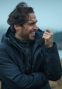 Mörkblå vindjacka med dragkedja fram, ståkrage och mjukt innerfoder. Avslappnad passform, textil med struktur, använd utomhus.