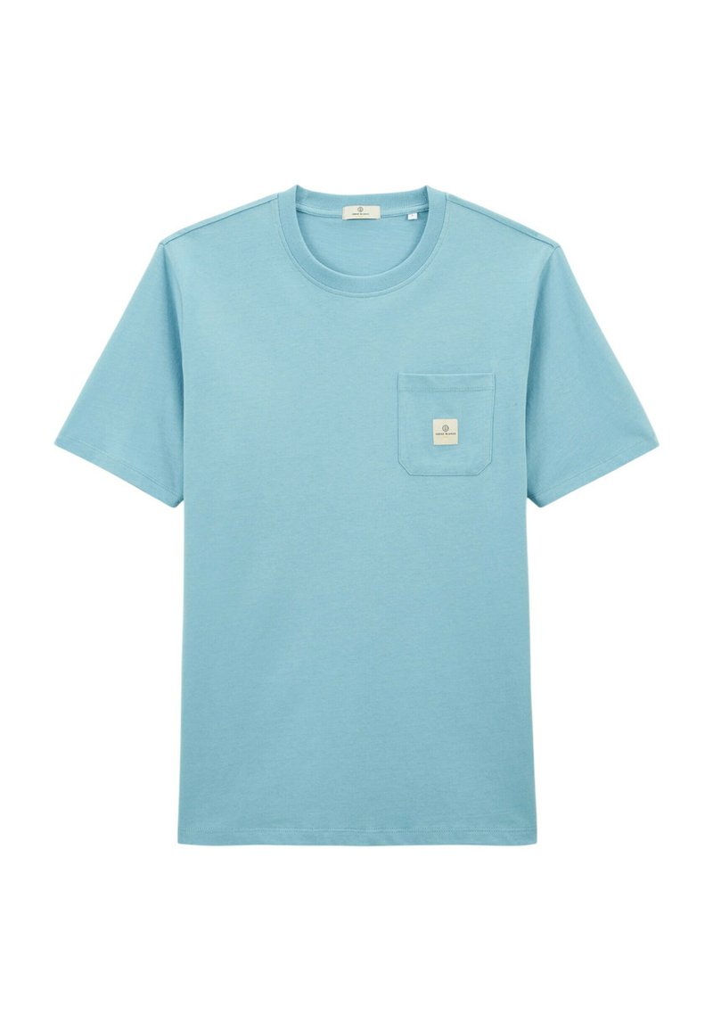 T-shirt en coton bleu clair à manches courtes, col rond, avec une petite poche poitrine ornée d'une étiquette. Texture lisse et unie.