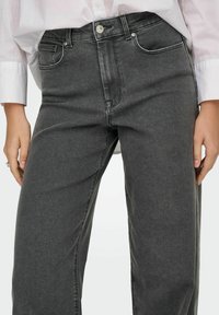 Hallid denim teksad sirge jalaga disainiga, kõrge vöökoht ja peened õmblemise detailid. Omab esipockets ja klassikalist nupulukk.