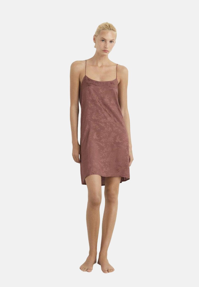 Vestido de tirantes finos color rosa empolvado, con un ajuste relajado y una sutil textura floral. Llega por encima de las rodillas y está hecho de una tela suave y ligera.