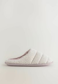 Pantofole trapuntate in morbido tessuto rosa chiaro con interno peluche e suola in gomma. Presentano un motivo testurizzato diagonale e una punta arrotondata.
