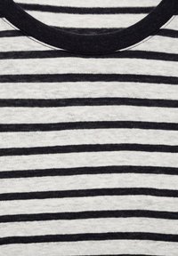 Striped t-shirt featuring thin black and white horizontal lines, a rounded neckline, and a soft, textured fabric.