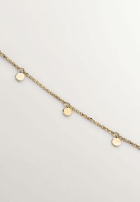 Pulsera de cadena en tono dorado con tres charm circulares. La cadena es delicada con eslabones alternos, y los charms tienen un acabado pulido.
