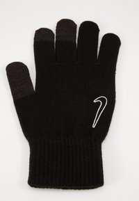 Sort strikket handske med ribbet manchet, der har et hvidt Nike-logo på håndleddet og mørkere nuancer på fingerspidserne.